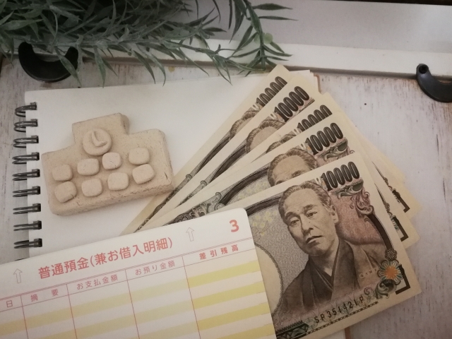 通帳と1万円札が並べてある画像